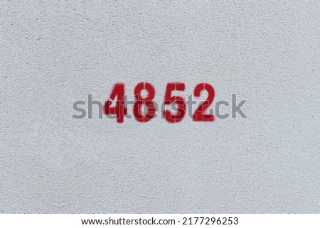 Red Number 4852 on the white wall. Spray paint.
