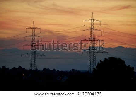 2 power pylons before sunset. Energy crisis in Europe because high electricity prices. Germany, Nurtingen. Royalty-Free Stock Photo #2177304173