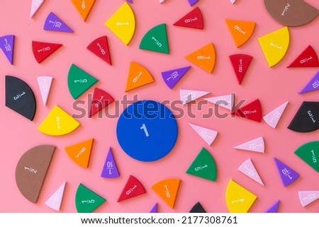 Violet orange yellow pieces of fractions on a table. Close up math material for study. Back to school, geometry lessons, mathematical education for preschooler. Creative study. background with numbers
