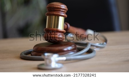 Close-up of judge gavel and medical stethoscope on office desk. Medical malpractice or personal injury lawyer. Healthcare legal aspects concept Royalty-Free Stock Photo #2177328241