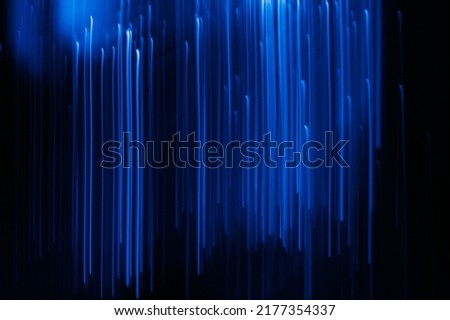 Defocused neon light. Fluorescent rays. Sci-Fi radiance. Blur UV navy blue color glowing lines motion on dark black presentation abstract background.