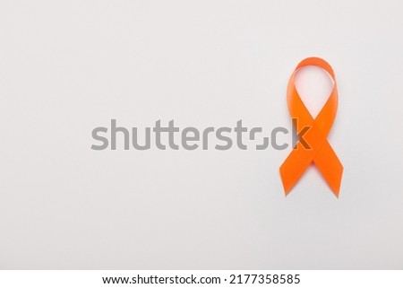 Orange awareness ribbon on grey background. Kidney cancer concept