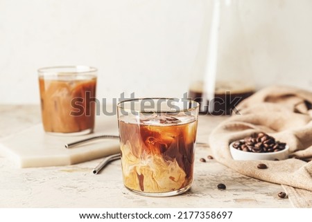 Delicious cold brew coffee with milk in glass on grunge table Royalty-Free Stock Photo #2177358697