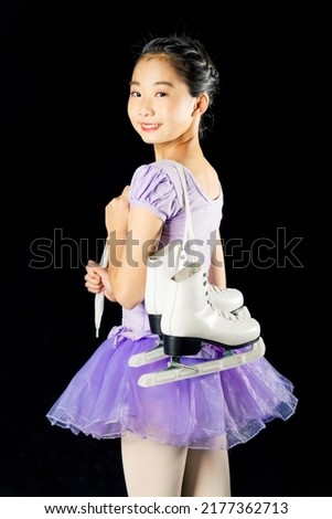 Asian girl carrying skating shoes. Figure skater.
