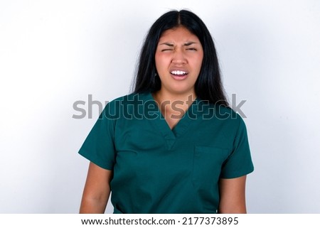 Doctor hispanic woman wearing surgeon uniform over white background yawns with opened mouth stands. Daily morning routine