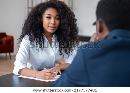 Black businesswoman looking at businessman, having an interview and answering question. Recruitment in business company. Concept of hr and future job Royalty-Free Stock Photo #2177377401