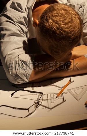 Young architect sleeping late at work in the office