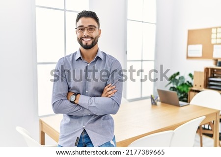 Young arab man smiling confident standing with arms crossed gesture at office Royalty-Free Stock Photo #2177389665
