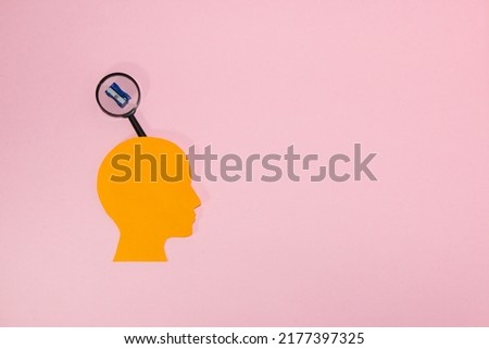 orange paper head with a cloud above, in it a sharpener, pink background and copy space, creative design in our head is the beginning of school and school obligations