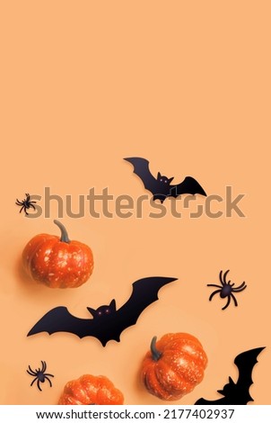 Orange Halloween background. Black bats and orange pumpkins. Autumn decoration. Halloween concept. Top view.