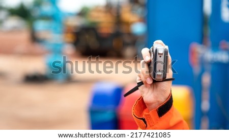 An auditor is using digital compact cemera taking photo during perform safety audit at construction site. Industrial working action scene photo, selective focus.