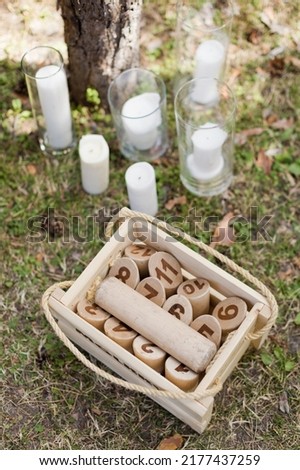 Traditional finnish game pieces Molkky near white candle on a grass