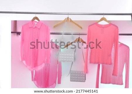 female pink blouses with sweater with white handbag , on hanger