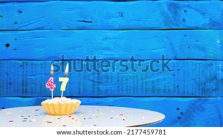  Festive background with a cake on the background of blue boards, copy space, a beautiful background for a birthday with a number a candle with a figure 47