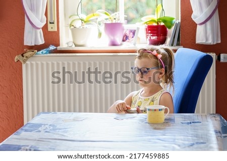 Little preschool girl with glasses playing card game. Happy healthy child training memory, thinking. Creative indoors leisure and education for family and kids.