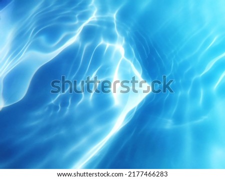 Closeup​ blur​ abstract​ of​ surface​ blue​ water. Abstract​ of​ surface​ blue​ water​ reflected​ with​ sunlight​ for​ background.Top​ view​ of blue​ water.​ Water​ splashed​ use​ for background.