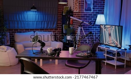 Empty internet online radio setup with headphones for producing podcasts and audio recording professional mixer on desk for social media. Nobody in podcast home studio with microphone boom arm.