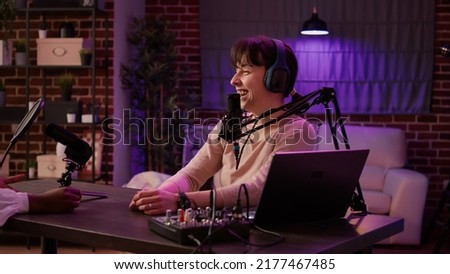 Online radio host having casual interview with african american singer in late night entertainment show in home studio. Content creator recording podcast with famous influencer for social media page.