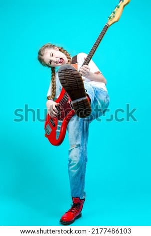 Caucasian Teenager Guitar Player With Red Shiny Bass Guitar Posing In Casual White Shirt Showing Stage Scenic Expression On Turquoise Background.Vertical Orientation
