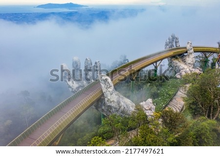Aerial view of the Golden Bridge is lifted by two giant hands in the tourist resort on Ba Na Hill in Da Nang, Vietnam. Destinations for tourists from Thailand, Korea, America and Japan are relax Royalty-Free Stock Photo #2177497621