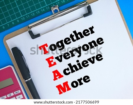 Top view of Text written Together Everyone Achieve More at white paper on clipboard, pen, calculator and cutting mate on Blue background 