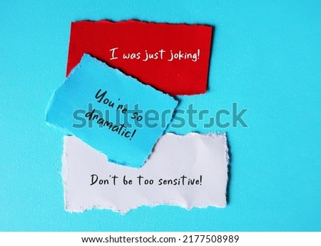 On blue background, torn paper with handwriting I WAS JUST JOKING, YOU'RE SO DRAMATIC and DON'T BE SO SENSITIVE, gaslighting verbal abuse use to manipulate and pin whole blame to victim Royalty-Free Stock Photo #2177508989
