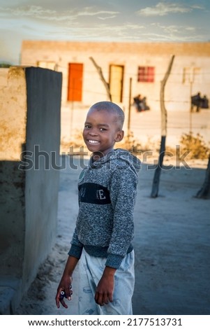 Portrait of a smiling african boy in the village at sunset Royalty-Free Stock Photo #2177513731
