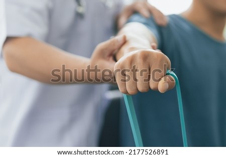 Physical therapists treat patients with exercises using latex therapy resistance band. Concept of physical therapy and rehabilitation. Royalty-Free Stock Photo #2177526891