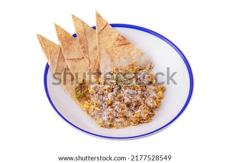 Lavash with basil, white sauce, corn and pieces of meat in a plate on a white plate