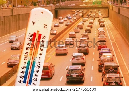 Thermometer in front of cars and traffic during heatwave in Montreal. Royalty-Free Stock Photo #2177555633