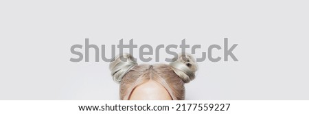 Close-up of two blonde hair buns. Panoramic banner view.