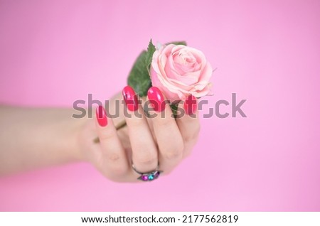 Pink manicured nails isolated on pink background. Pink lips.