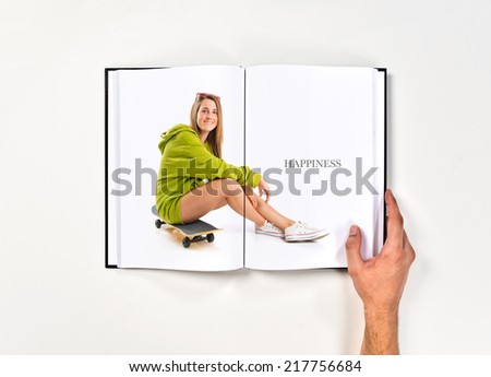 Pretty young girl with skateboard printed on book