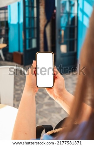 Girl with a screen phone in a cafe on the street