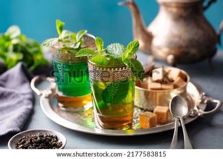 Moroccan mint tea in traditional glasses with sugar on silver tray. Close up. Royalty-Free Stock Photo #2177583815