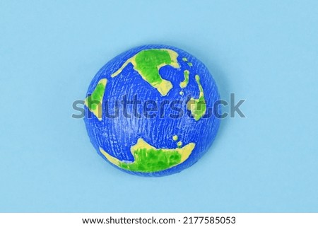Small planet earth model on blue background