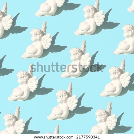 Cupid plaster figures, creative pattern on baby blue background. Love and passion concept. 