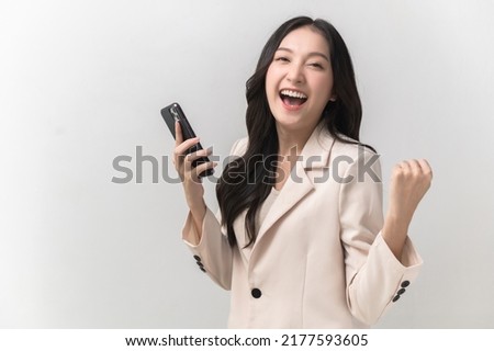 Portrait photo of young beautiful Asian woman feeling happy or surprise shock and holding smart phone on white background can use for advertising or product presenting concept.