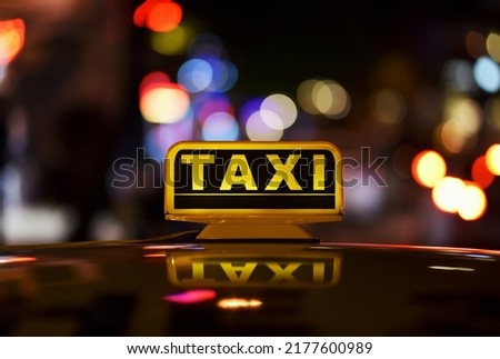 Taxi sign on roof car in night city with bokeh effect