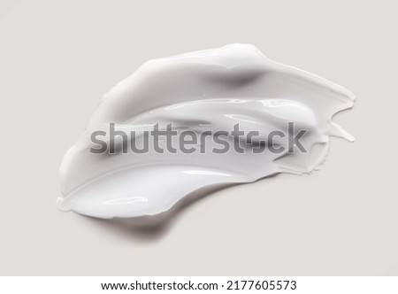 Cosmetic white cream balm texture smudge isolated on gray background Royalty-Free Stock Photo #2177605573