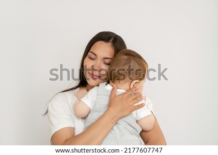 Happy young mother with her baby, little son in love on a white background. The concept of a happy family, motherhood. mother and child portrait Royalty-Free Stock Photo #2177607747
