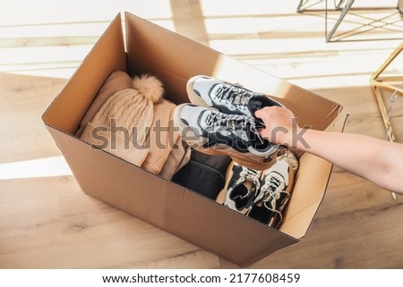 Volunteer with donations for poor people. Cardboard box with clothes for charity. Help poor. Woman holding a donate box. Case full of clothing for poor giving. Sharity social activity. Royalty-Free Stock Photo #2177608459