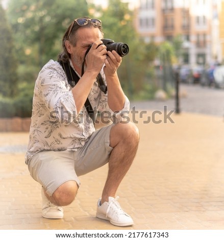 man tourist with camera in the city. Man making picture of city sights.