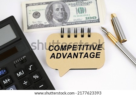 Business concept. On a white surface, a calculator, dollars, a pen and a sign with the inscription - COMPETITIVE ADVANTAGE