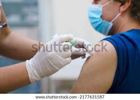 Man getting vaccinated against covid. Vaccination routine, adult immunization schedule. Seasonal virus protection, monkeypox vaccine. Outbreak disease prevention. Medical nurse hold injection syringe Royalty-Free Stock Photo #2177631587