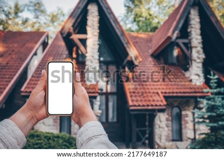 Phone with isolated screen on the background of the cottage