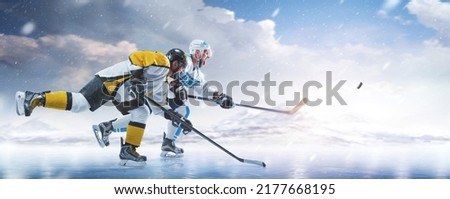Hockey. Two professional hockey player in action. Fight for the puck on ice. Sports emotions. Side view. Winter sport. Speed