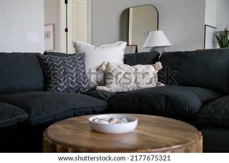 Couch with decorative throw pillows behind a coffee table with a bowl of shells