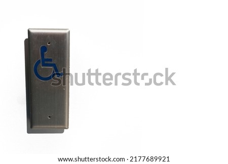 Close up of a silver metal push button switch with wheelchair and disabled person icon on white background as concept for request for help and assistance
