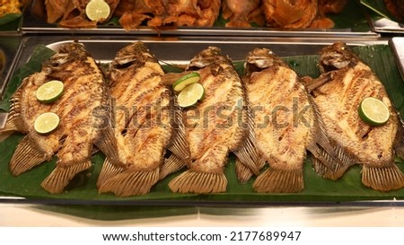 Flavoured carp fishes with slices of lime ready to be fried, placed on banana leaf sheet